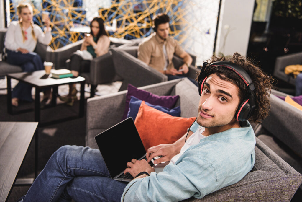 Man working in coworking space with headphones on