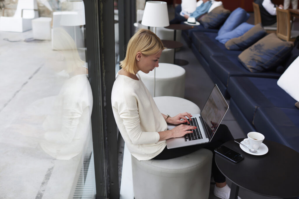 Modern business woman or young successful working on laptop computer while sitting at coffee shop interior, female student sitting in university library with net-book, internet distance work concept