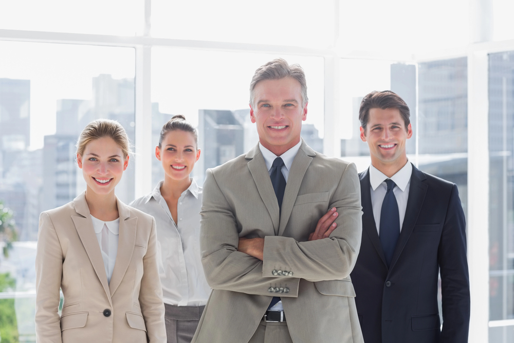 Happy boss standing with his employees