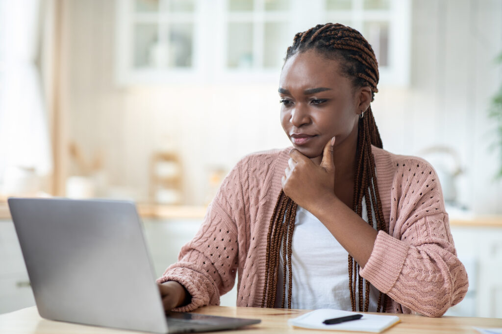 Stressed freelancer woman looking at laptop screen while working at home